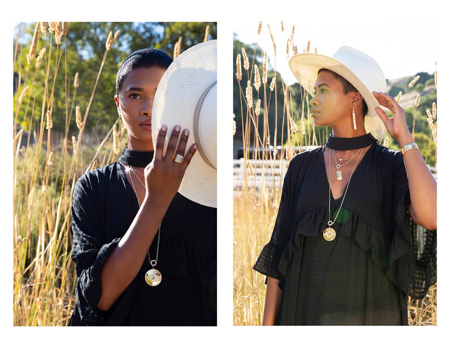 Woman in nature wearing white hat and pendant necklaces, rings, earrings, bracelets for Good Juju Collection