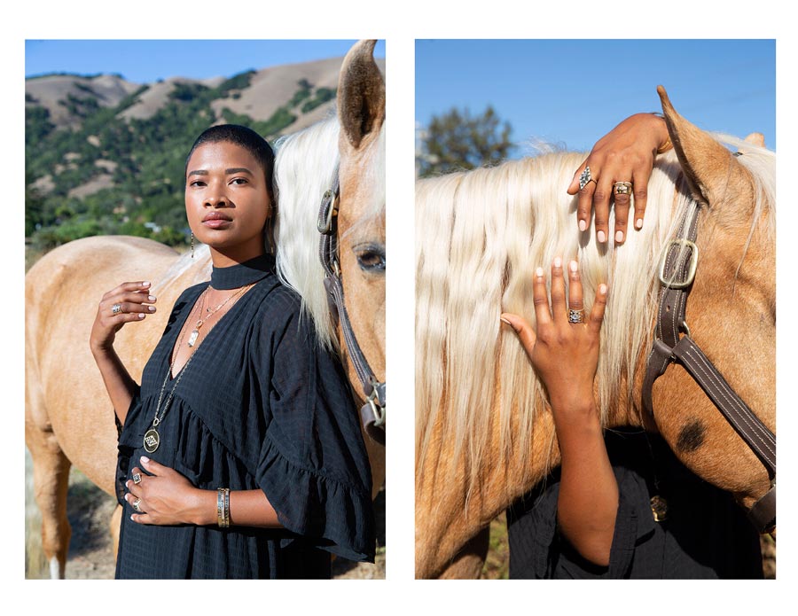 Woman standing with horse outdoors wearing rings, pendant necklaces, bracelets, earrings for Good Juju Collection