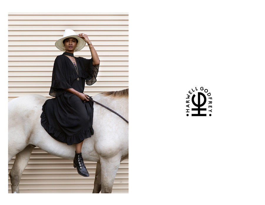 Woman on a horse with a white hat looking at camera for Good Juju Collection