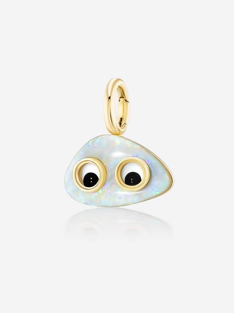 Slightly angled close-up of Lil’ Buddies Pendant Elton, glowing white opal in 18k yellow gold with crystal and onyx googly-eye details.
